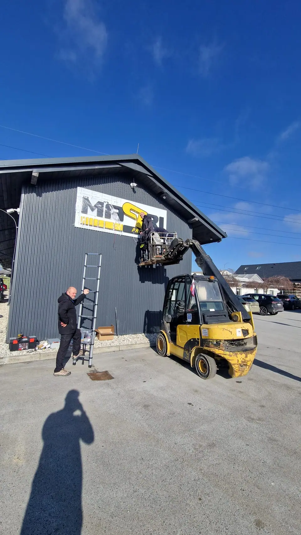 Installing the Mapri sign on the building facade with a forklift